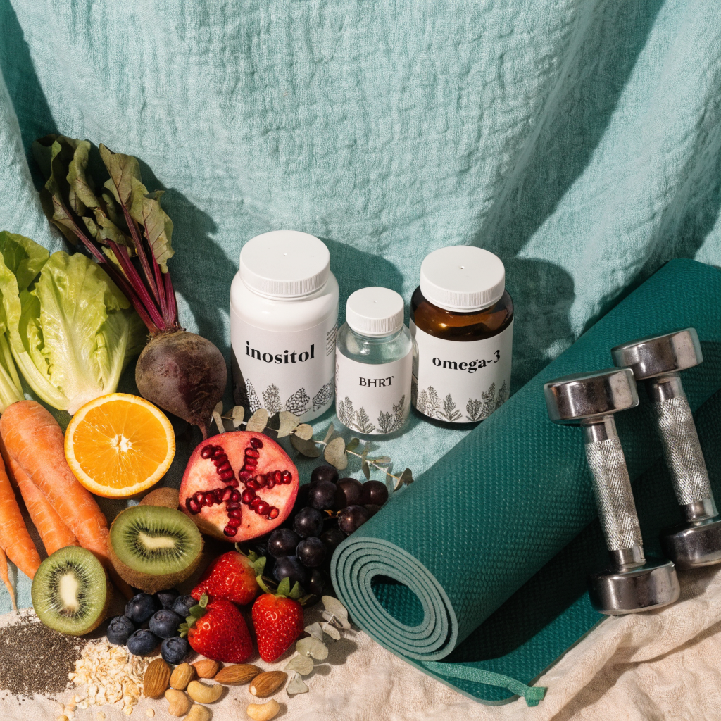 A flat lay showing the holistic approach to PCOS management combining BHRT with diet, exercise, and supplements